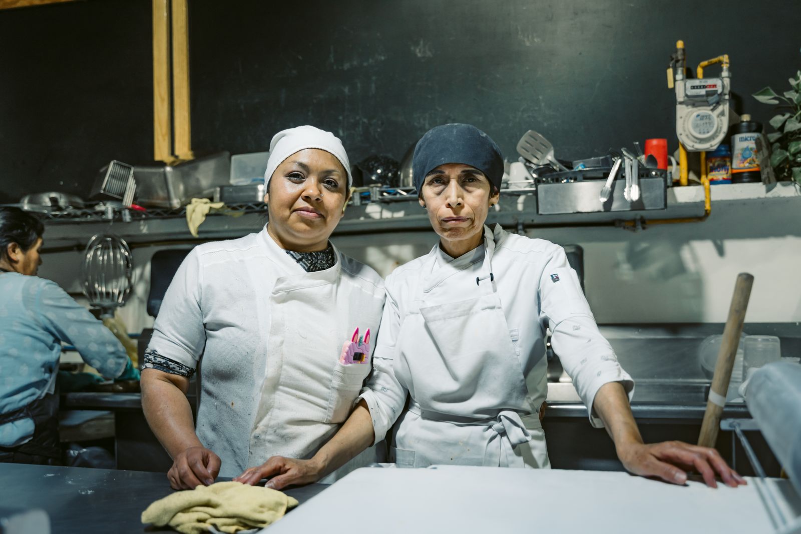 Two skilled chefs in a Mexican restaurant kitchen, showcasing teamwork and culinary expertise.