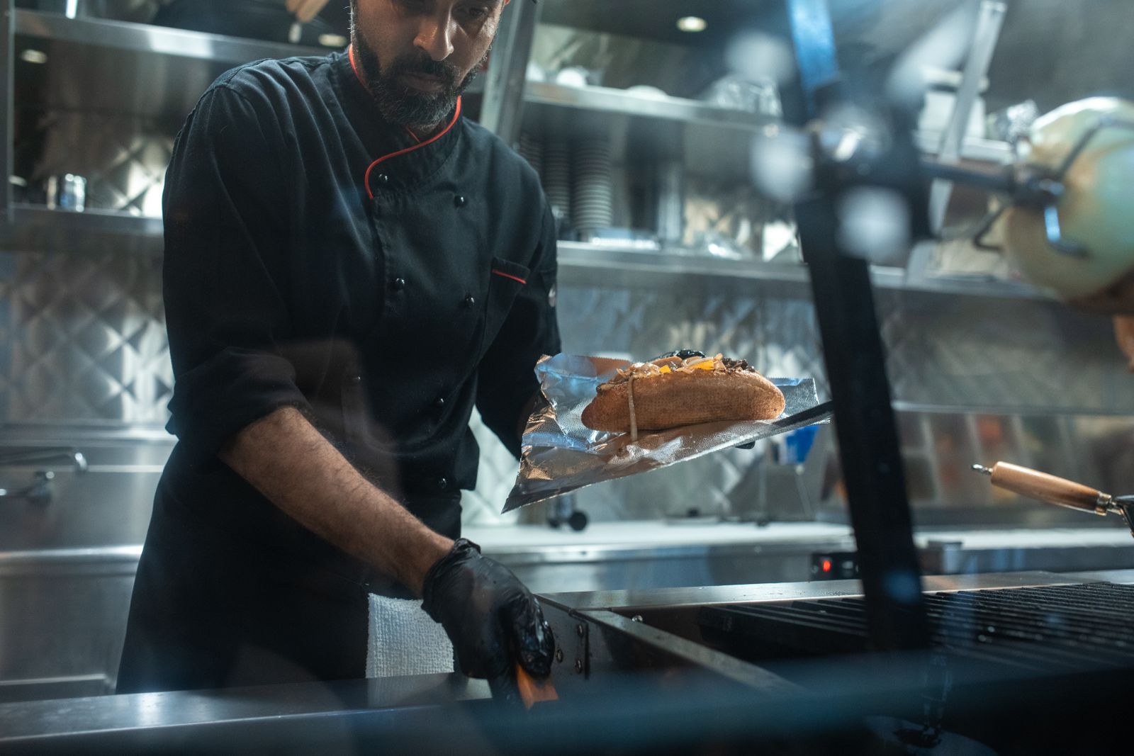 Cook finishing a grilled sandwich on the flat-top